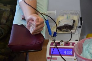Zaciśnięta w pięść dłoń. Z ręki, wężykiem, spływa krew.
