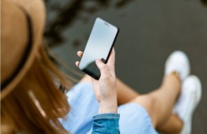 kobieta trzyma w dłoni telefon - widok z góry
