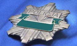 Na niebieskim tle widoczna policyjna odznaka