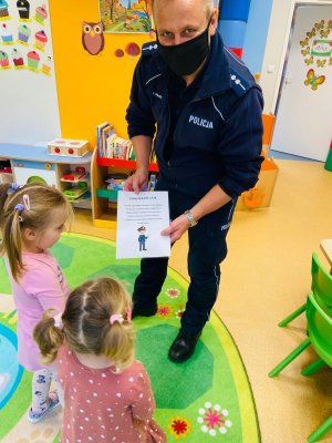 Policjant otrzymuje od dwóch dziewczynek podziękowanie