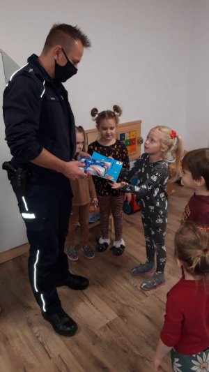 Policjant otrzymuje od grupy dzieci podziękowanie