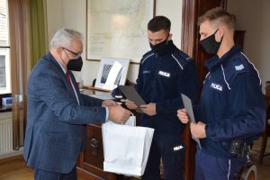 Burmistrz Pan Arkadiusz Czech wręcza policjantom tarnogórskiej komendy sierż. szt. Krzysztofowi Lach oraz st. post. Robertowi Szlenk listy gratulacyjne.