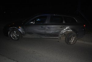 Na zdjęciu widać bok samochodu osobowego. Auto jest zarysowane i ma uszkodzone tylne koło