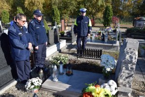 Pierwszy Zastępca Komendanta Powiatowego Policji w Tarnowskich Górach komisarz Waldemar Czapla,  Kapelana Policji diecezji gliwickiej ksiądz Joachima Gondro i policjant z drogówki stoją obok grobu policjanta.