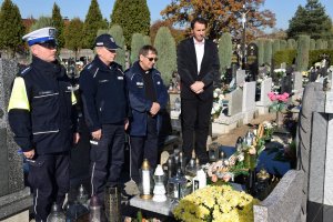 Pierwszy Zastępca Komendanta Powiatowego Policji w Tarnowskich Górach komisarz Waldemar Czapla, Komendant Komisariatu Policji w Kaletach nadkomisarz Tomasz Olczyk,  Kapelana Policji diecezji gliwickiej ksiądz Joachima Gondro i policjant z drogówki stoją przy grobie policjanta