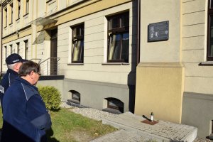 Pierwszy Zastępca Komendanta Powiatowego Policji w Tarnowskich Górach komisarz Waldemar Czapla wraz z Kapelanem Policji diecezji gliwickiej księdzem Joachimem Gondro stoją przed tablicą upamiętniającą pomordowanych policjantów.