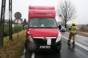 Na zdjęciu widać samochód marki Opel, który ma uszkodzony prawy bok. Obok samochodu widać strażaka, policyjny radiowóz i policjanta