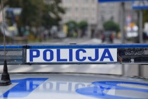 Zdjęcie przedstawia umiejscowiony na dachu radiowozu &quot;policyjny kogut&quot;, na którym widnieje napis Policja.