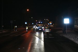 Na zdjęciu widać przejście dla pieszych. Za przejściem stoi samochód osobowy, a przed nim policyjny radiowóz. Widać również policjantów wykonujących czynności.