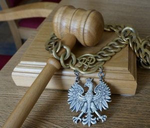 Na zdjęciu widać sędziowski młotek, na którym znajduje się łańcuch z Godłem.