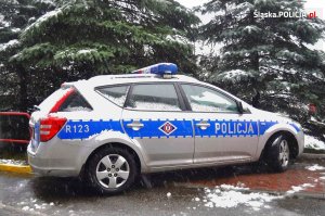 Na fotografii widać zaśnieżony policyjny radiowóz