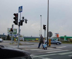 Pieszy przechodzący przez przejście z sygnalizacją świetlną. Sygnalizacja pokazuje światło czerwone.