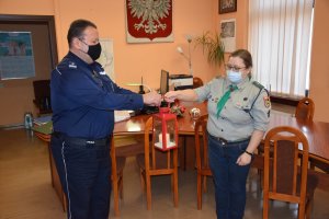 Harcerka przekazuje Komendantowi latarenkę z Betlejemskim Światłem Pokoju