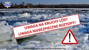 Widok rzeki z kawałkami kry i lodu w oddali drzewa i budynki mieszkalne.  Na środku zdjęcia napis UWAGA NA KRUCHY LÓD, UWAGA NIEBEZPIECZNE ROZTOPY.