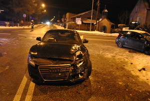 Samochód marki Audi, który ma uszkodzony przód oraz bok. W tle widać uszkodzonego citroena.