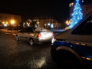 Na zdjęciu widać policyjny radiowóz, przed którym znajduje się kontrolowany samochód.