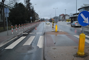 Przejście dla pieszych. W tle widać policyjny radiowóz i autobusy zaparkowane na dworcu.