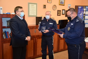 na zdjęciu widać komendanta powiatowego policji w tarnowskich górach i jego zastępcę gratulujących odchodzącemu na emeryturę komendantowi komisariatu policji w Radzionkowie