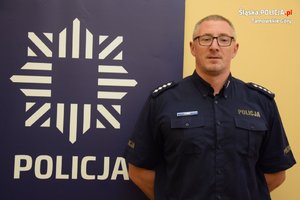 na zdjęciu kierownik rewiru dzielnicowych w niebieskim mundurze, z lewej strony logo policji