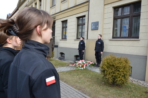 uczniowie klasy policyjnej pod pamiątkową tablicą w komendzie policji