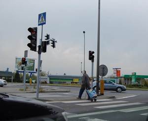 osoba przechodzącą przez przejście dla pieszych na czerwonym świetle