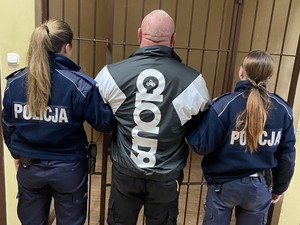 dwie policjantki trzymające za ręce zatrzymanego