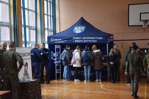 duże pomieszczenie, w którym widać, rozmieszczony w rogu, policyjny namiot koloru niebieskiego