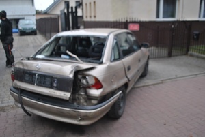 uszkodzony pojazd stojący przed bramą posesji