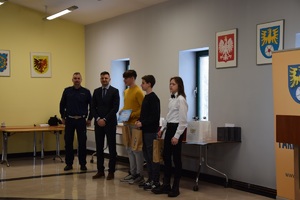 uczniowie z nagrodami konkursowymi z przedstawicielem gminy miasteczko śląskie oraz policjant