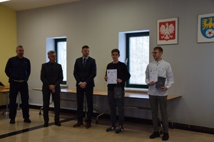 uczniowie z nagrodami, wice starosta i policjant