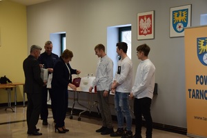 uczniowie odbierający nagrody z rak władz powiatowych