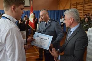 przedstawiciel policji i władz powiatowych wręczający uczniom certyfikaty