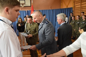 przedstawiciel policji i władz powiatowych wręczający uczniom certyfikaty