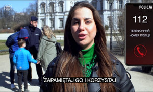 kobieta w trakcie wypowiedzi, w tle policjant i inne osoby