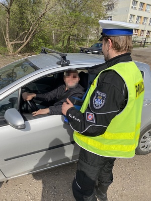 policjant rozmawiający z kierującym samochodem w trakcie kontroli