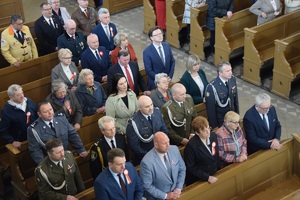 osoby stojące przy kościelnych ławkach