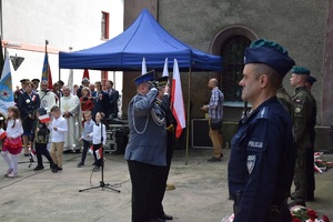 komendant policji i straży miejskiej oddający honor przed pamiątkową tablicą
