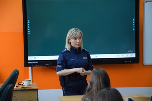 policjantka w szkolnej klasie, za nią tablica