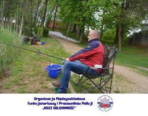 mężczyzna w fotelu przy zbiorniku wodnym, w ręce trzyma wędkę, w dolnej części logo organizacji związkowej