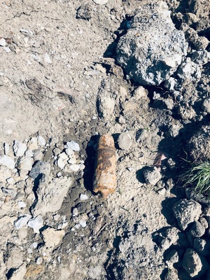 leżący na ziemi skorodowany niewybuch