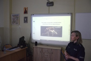 policjantka, za nią na ekranie prezentacja mulitmedialna