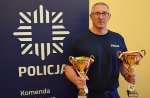 policjant w mundurze z dwoma pucharami