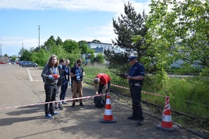 policjant w mundurze, obok niego uczniowie