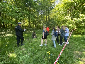 na trafie żołnierz z pistoletem w ręku, podchodzący do niego uczestnicy zawodów, w roli sędziego policjant w białej czapce