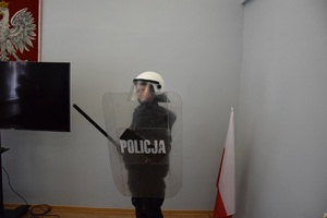 uczeń w ubiorze policyjnym i tarczą