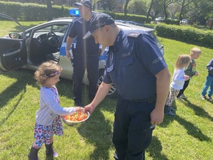 policjant rozdaje dzieciom cukierki