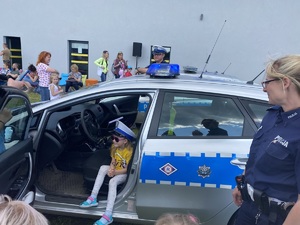 dziecko w policyjnej czapce w radiowozie, obok policjantka