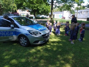 policyjny radiowóz a przy nim dzieci
