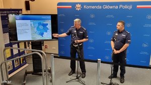 policjanci w trakcie spotkania z mediami, stoją przy telewizorze