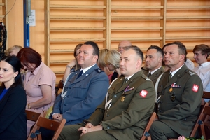 w centralnej części zdjęcia komendant policji, obok niego inni mundurowi oraz osoby